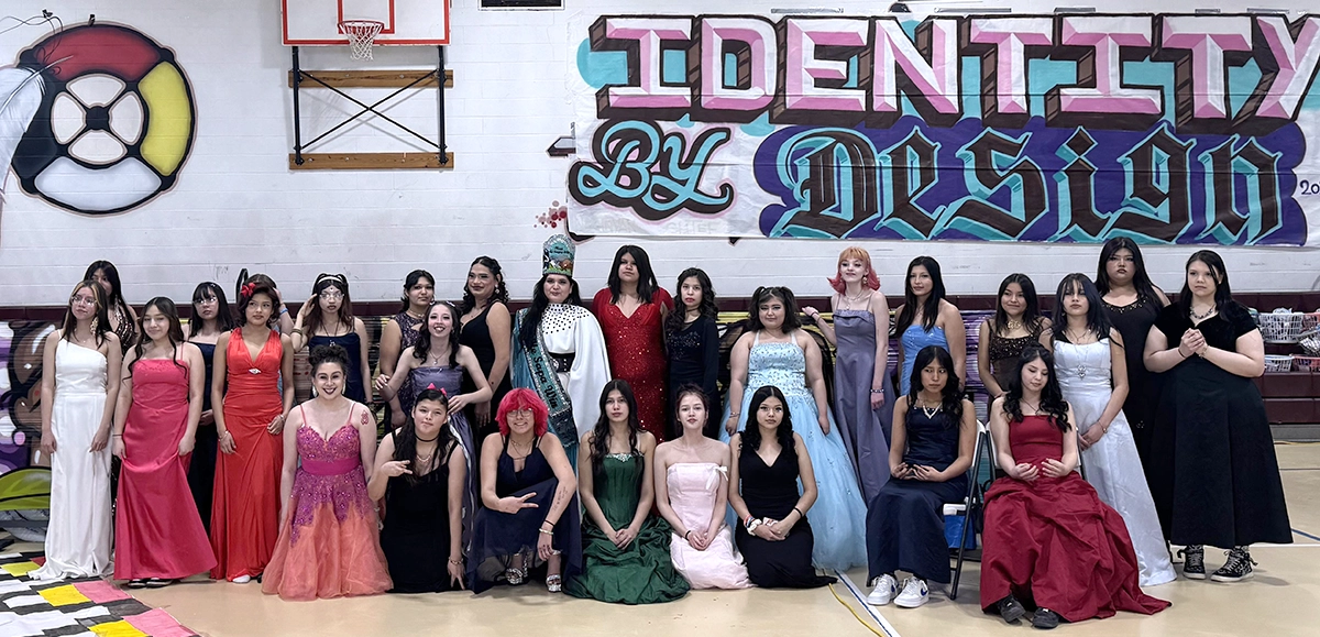 Group photo of young people in formal dress in front of banner saying "Identity by Design"